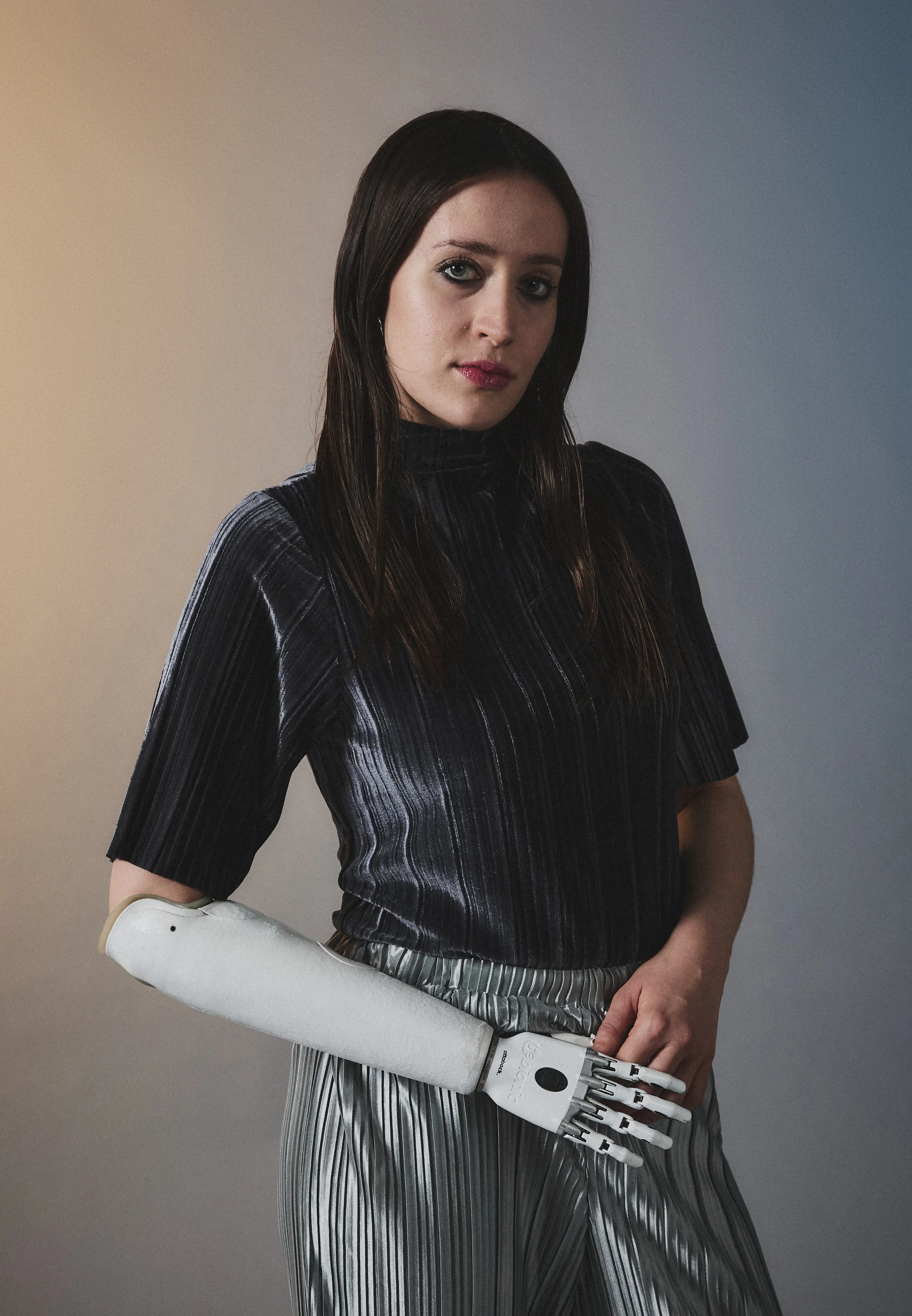 Woman with prosthetic arm wears high neck dark blue silver top